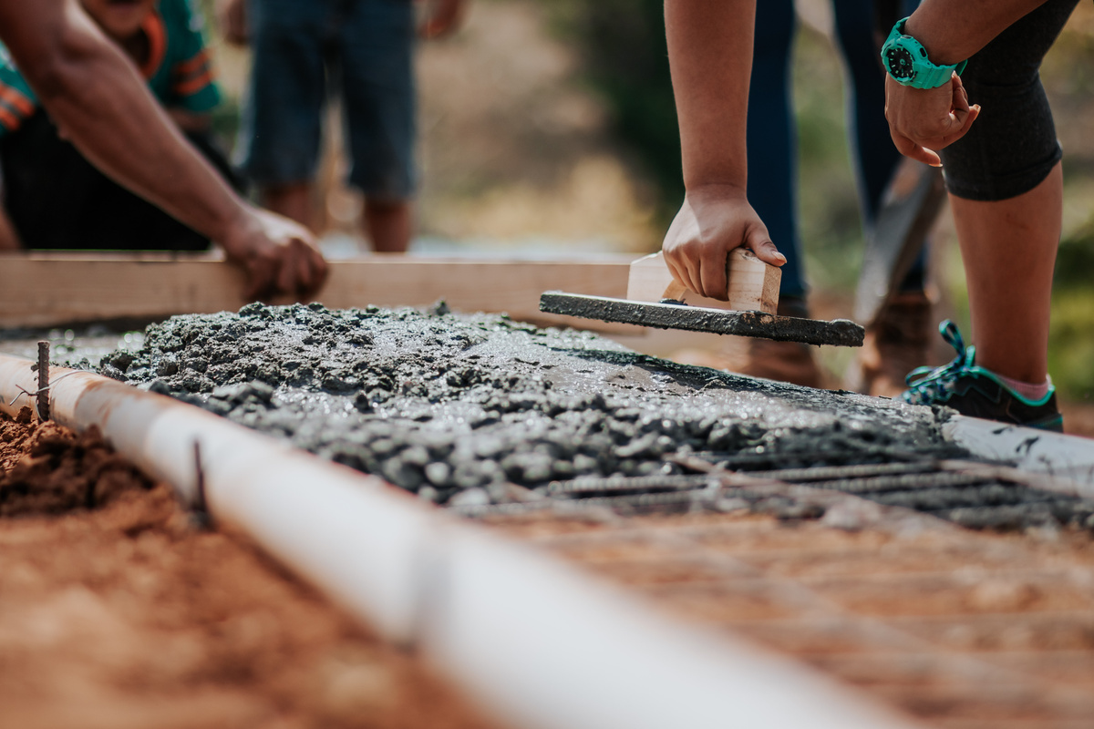 a group of people working on a concrete walkway