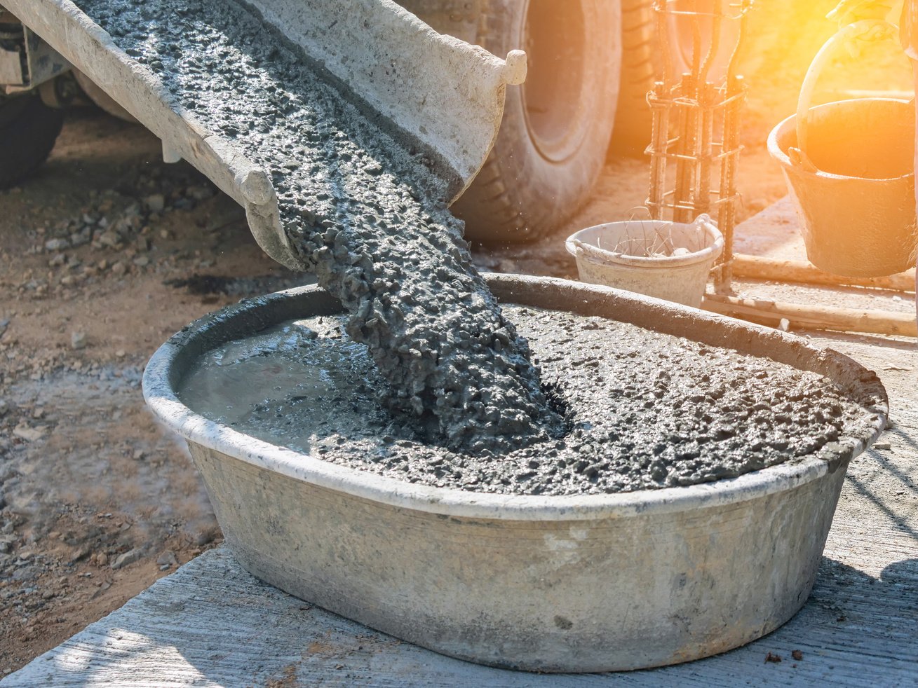 concrete being poured into a bucket on a construction site